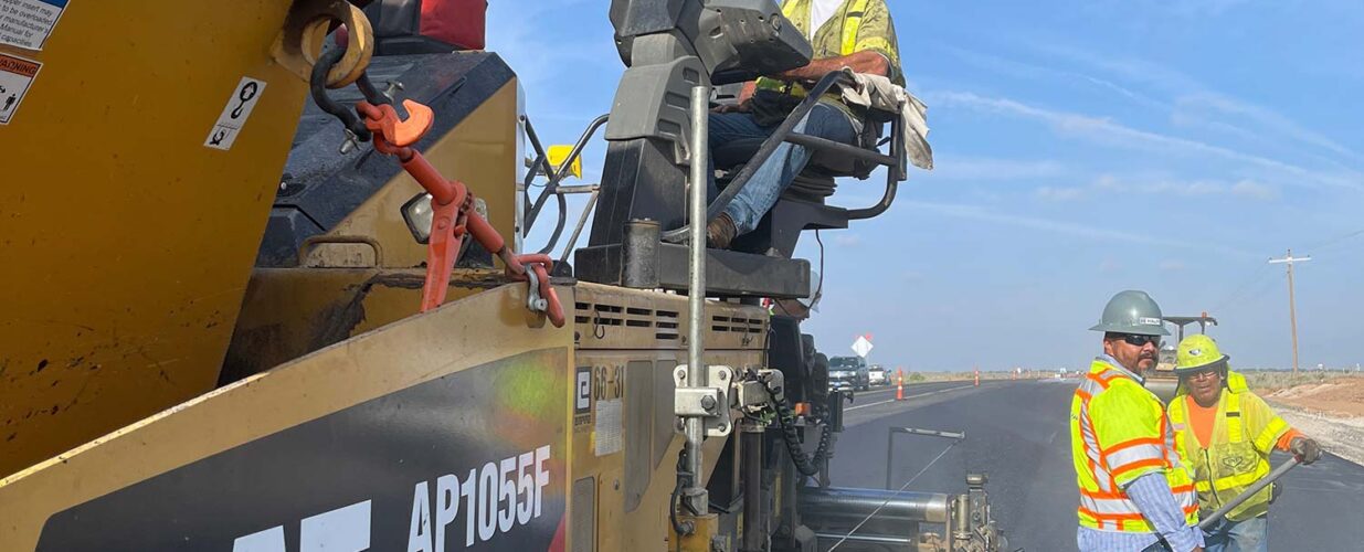 construction workers paving road at SH 302